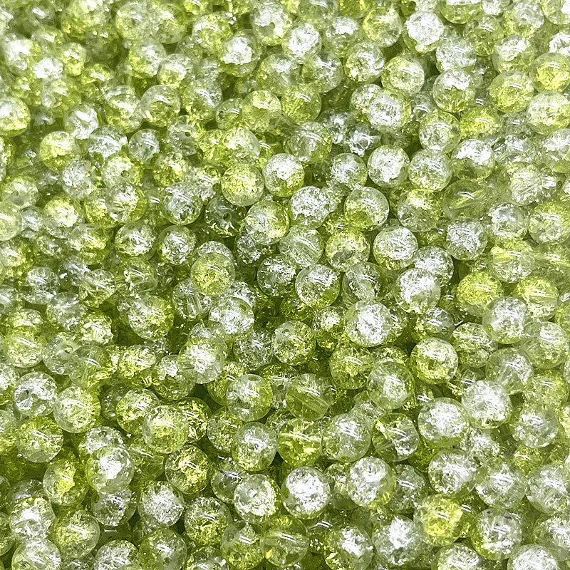 Close-up view of round, translucent lime green glass crackle beads for jewelry making