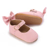 Pink lace-trimmed baby girl moccasin shoes with a bow