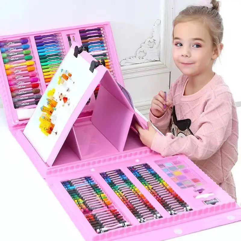 A young girl is holding a pink portable art set with an easel and numerous colored art supplies.