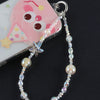 A pearl crystal star phone charm with a bag clip is displayed next to a pink and yellow fish-shaped charm.