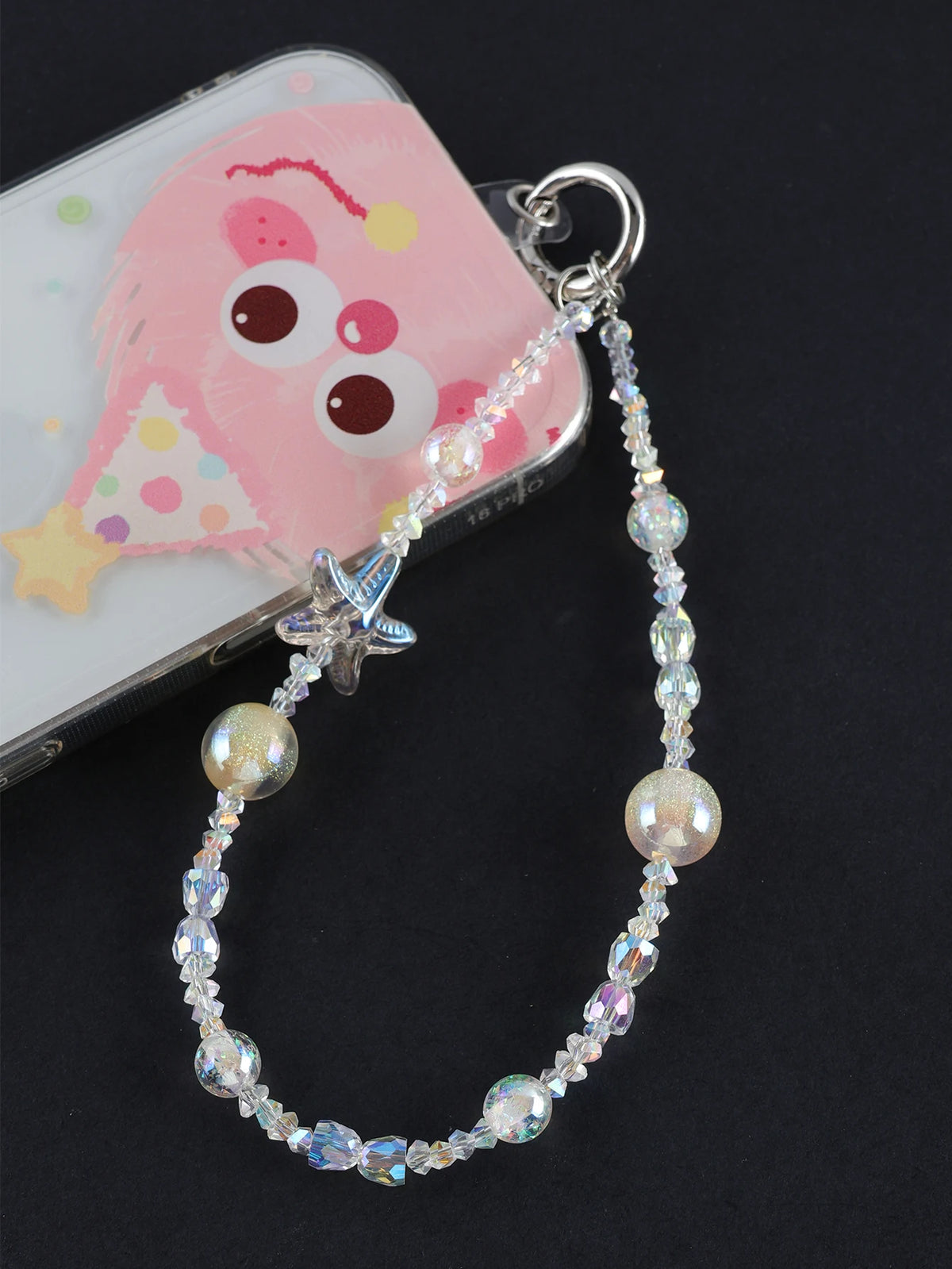 A pearl crystal star phone charm with a bag clip is displayed next to a pink and yellow fish-shaped charm.