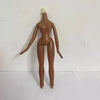 A brown fashion doll with a white hairpiece standing against a white background.