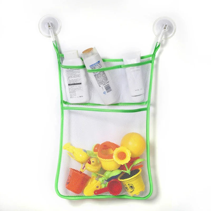A mesh storage bag with suction cups holds various bath toys including ducks and frogs.