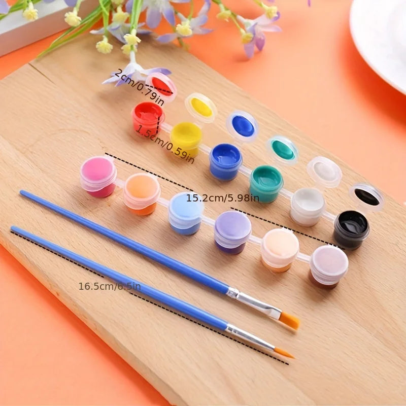 A wooden board displays a set of twelve acrylic paint pots in various colors and a brush for crafts and art projects.
