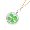 A clear glass four leaf clover pendant on a gold chain, suitable for jewelry making.