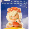 A fluffy, light-colored collectible figure resembling a pony with an orange hat and an apple accessory is displayed against a