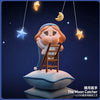 A figurine of a crying girl with blue hair and a blue dress is perched on a cloud, with crescent moon and star charms hanging