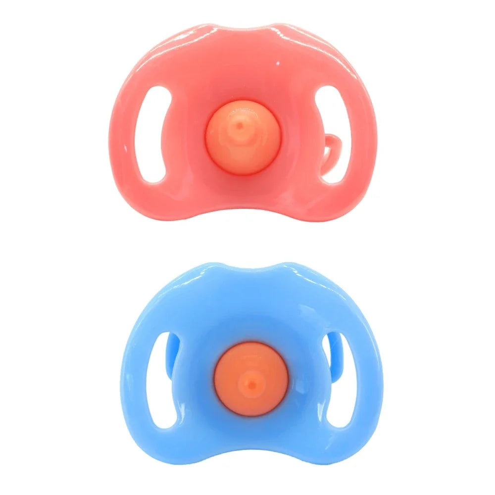 A pair of large silicone feeding bottles in pink and blue with orange centers and attached pacifiers.