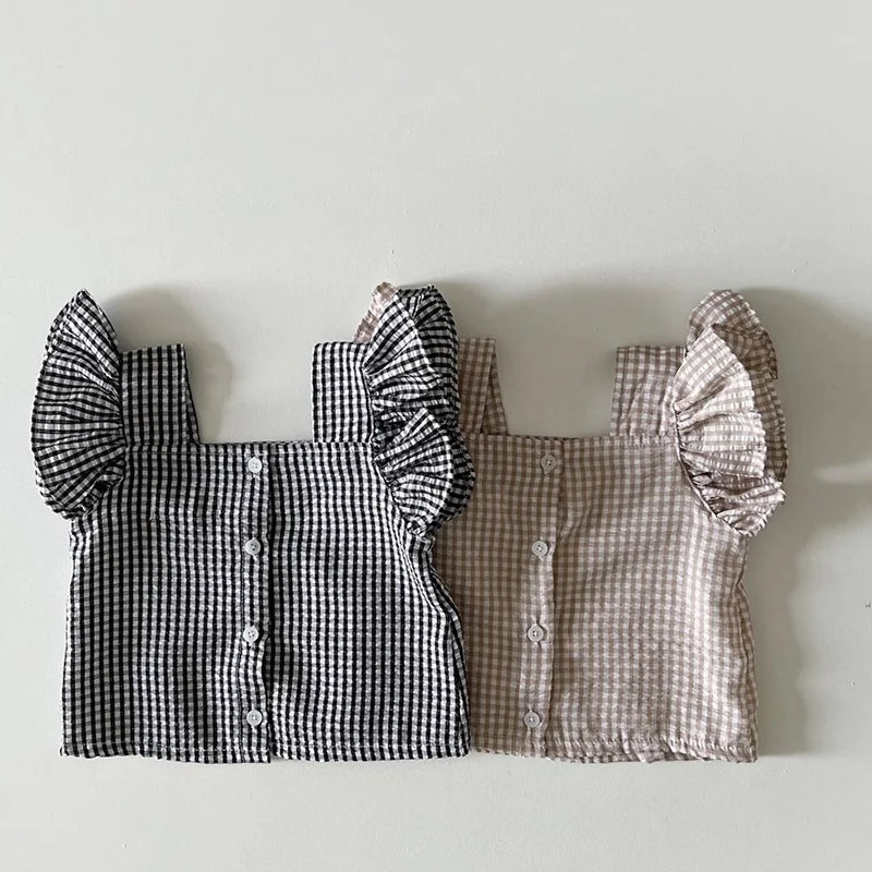 A baby girl ruffle top and shorts set in a gingham pattern, featuring black and white and beige patterns.