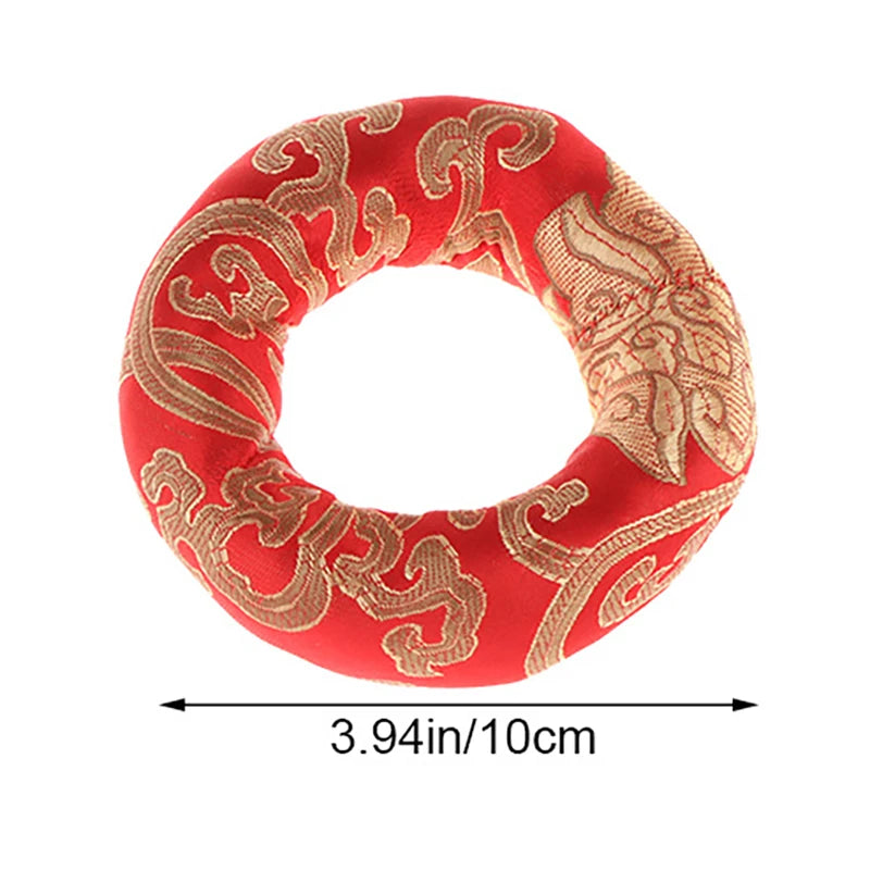 Handmade red singing bowl cushion featuring intricate gold embroidery