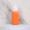 An orange bottle of water marbling paint art kit for kids with a white cap sitting on a white surface.