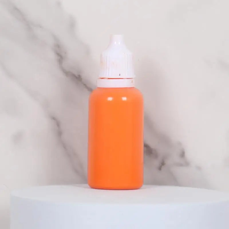 An orange bottle of water marbling paint art kit for kids with a white cap sitting on a white surface.