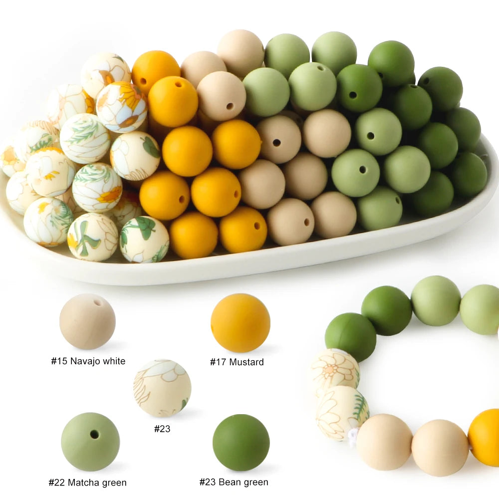 A collection of soft food-grade silicone beads in various colors including white, yellow, and shades of green.