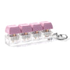 A set of four pink acrylic keycap fidget buttons packaged in a clear plastic case with a metal keychain ring.