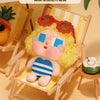 A yellow-haired vinyl figure wearing a flower crown is seated in a wooden chair, displayed as a Crybaby Vacation Mode On item