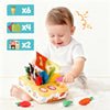 A baby is playing with a soft pulling carrot sensory toy box and several loose carrots.