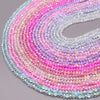 A close-up of multicolored faceted crystal rondelle beads arranged in a spiral pattern.