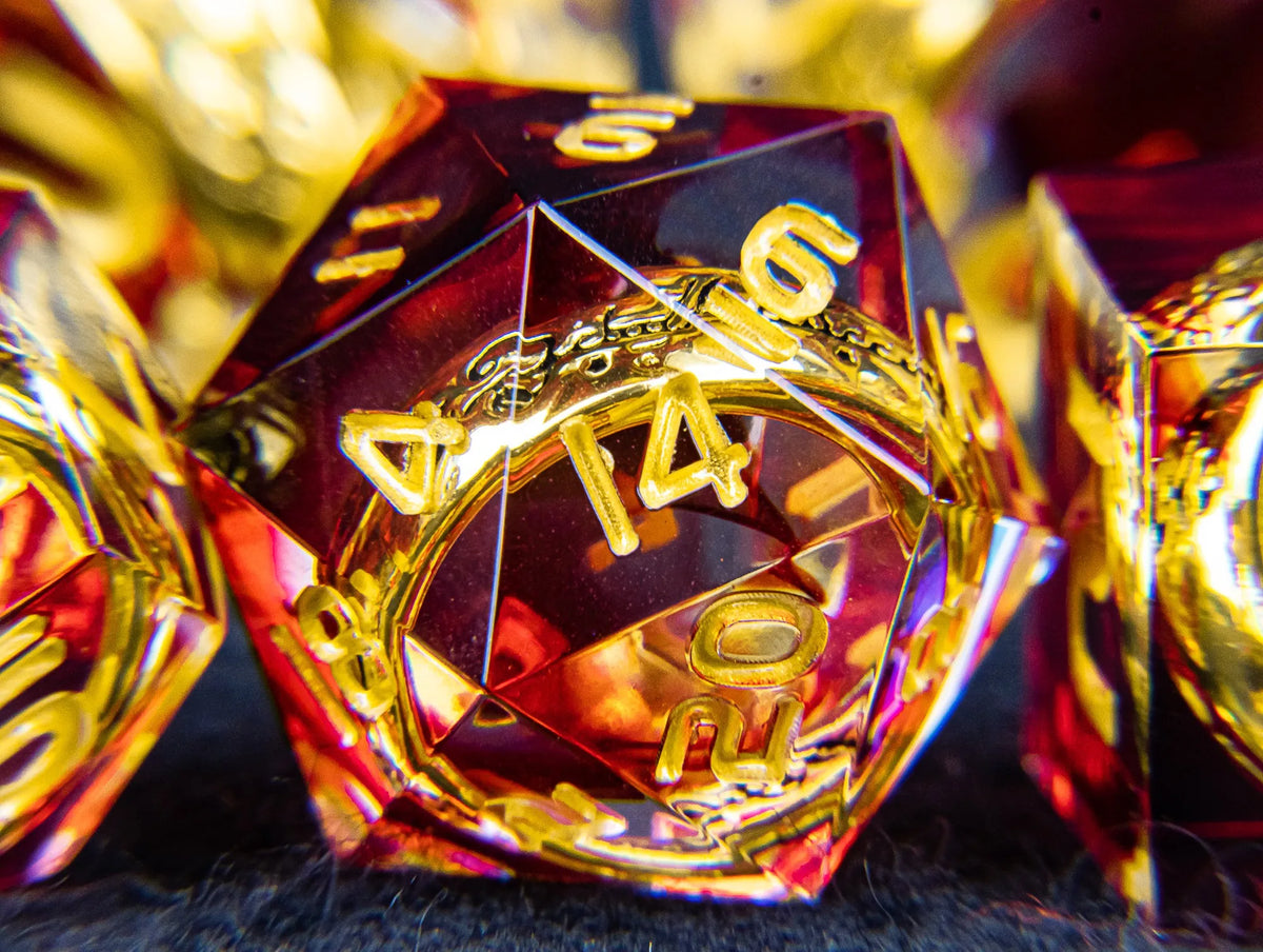 A close-up of a translucent red resin die with golden elven numbers, set against a dark background.