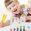 A young girl is using a wooden test tube toy with colorful beads to develop fine motor skills.