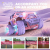 A pink 1:16 scale remote control off-road car with purple tires and lights driving on a sandy terrain.