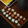 A collection of small, colorful hexagon silicone resin molds shaped like dice, arranged on a wooden surface.