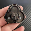 A close-up of a premium metal magnetic fidget slider with a ribbed design held in a hand.