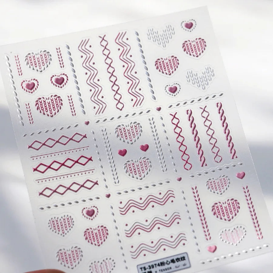 Sheet of nail art stickers featuring various heart and geometric patterns in pink and gray tones