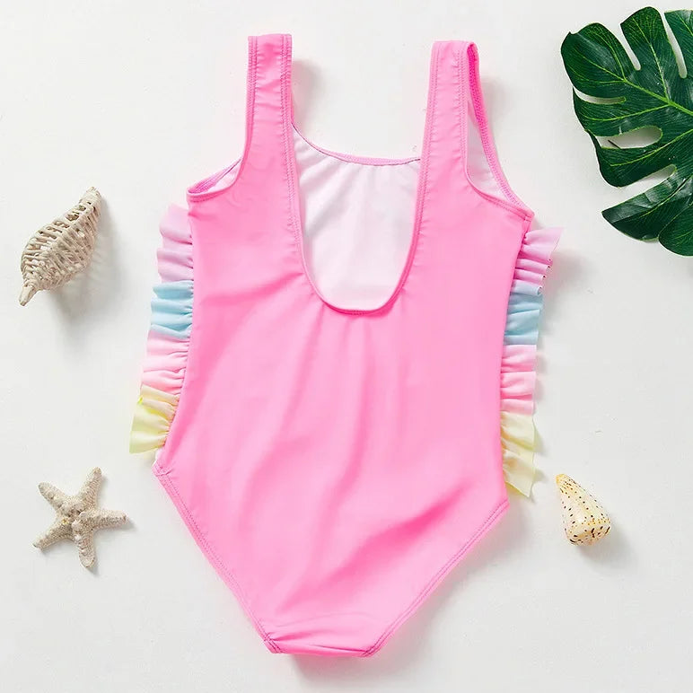 A bright pink kids mermaid unicorn one-piece swimsuit with colorful ruffled trim is displayed on a white background.