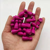 A hand holds a set of ten magenta wooden chess pawns for board games.