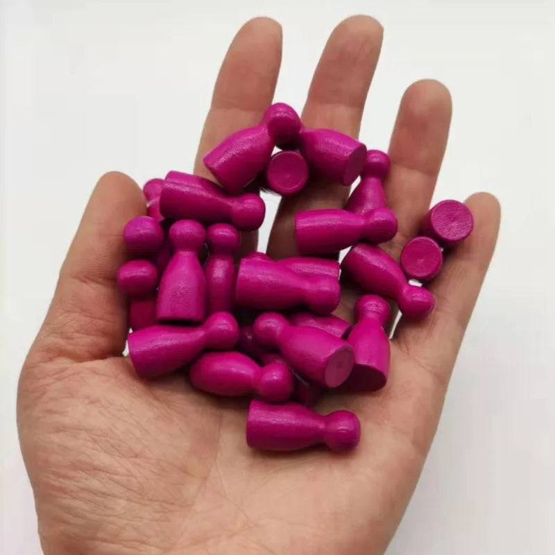 A hand holds a set of ten magenta wooden chess pawns for board games.