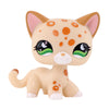 A cute, light orange and white spotted cat figure with large green eyes.