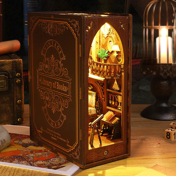 A wooden book nook puzzle kit with an arched window displaying a miniature library scene and warm lighting.
