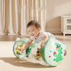A baby is playing with a green Montessori crawling roller toy on a light carpet.