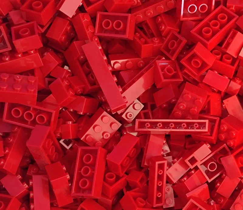 A pile of red and pink plastic building blocks.