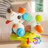 A white cartoon baby rattle toy with various colored parts and a suction cup base sitting on a table.