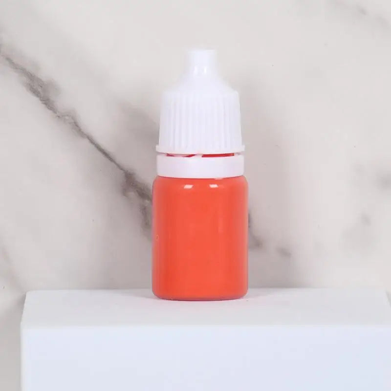 An orange bottle of water marbling paint art kit for kids with a white cap sitting on a white surface.