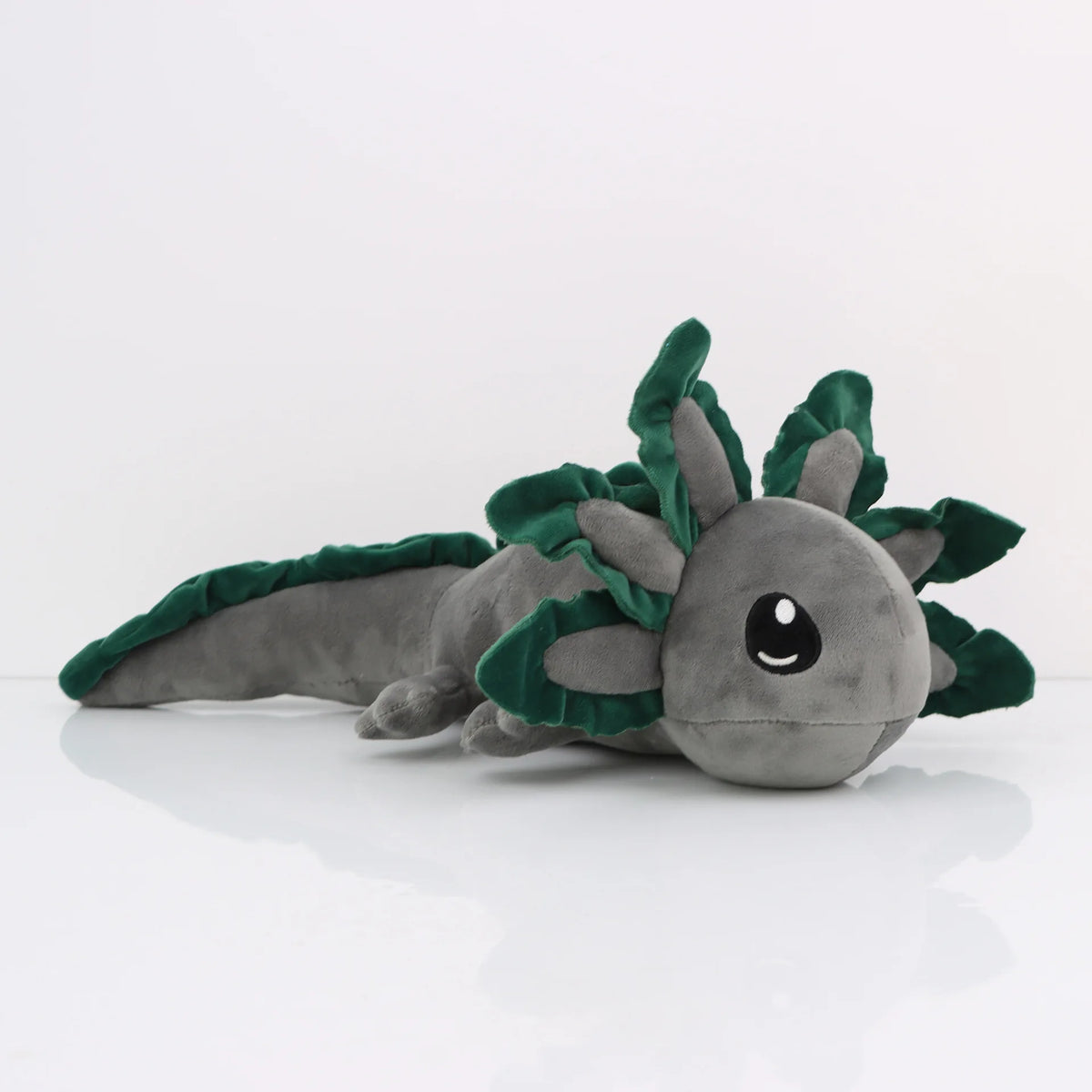 A soft gray and green plush toy of an axolotl with leafy accents.