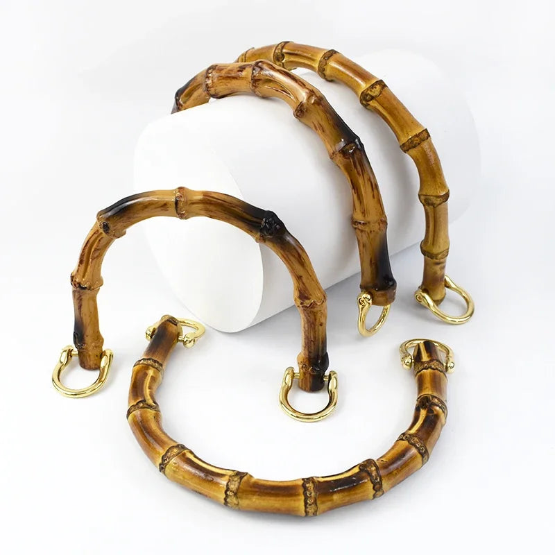 A set of natural bamboo-style bag handles with gold-colored loops, displayed on a white background.