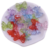 A collection of 20 colorful acrylic bow beads in shades of green, purple, blue, and red arranged on a white plate.