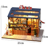 A wooden miniature Japanese restaurant dollhouse kit featuring a display case and interior food items.