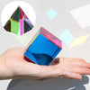 A hand holds a colorful CMY prism cube, demonstrating 3D color mixing for photography and decor.