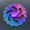 A colorful metal fidget spinner with a purple and blue iridescent finish.