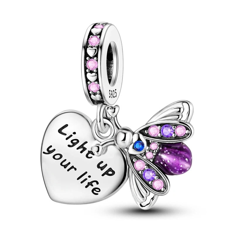 A silver heart charm bead featuring pink zircon stones and a butterfly design.