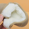 A hand holds a tan leather winter boot with a thick white faux fur lining.