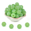 A pile of bright green rhinestone resin bayberry beads for jewelry making.
