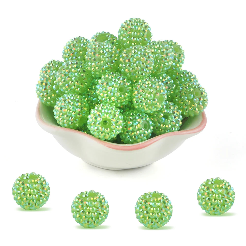 A pile of bright green rhinestone resin bayberry beads for jewelry making.