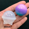 A hand holds a purple glitter sphere and a clear silicone mold for resin crafting.