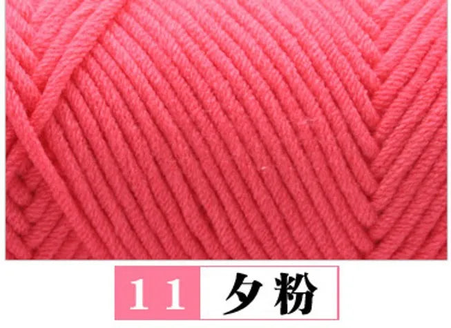 A close-up of bright pink premium milk cotton yarn with a diagonal knit pattern.