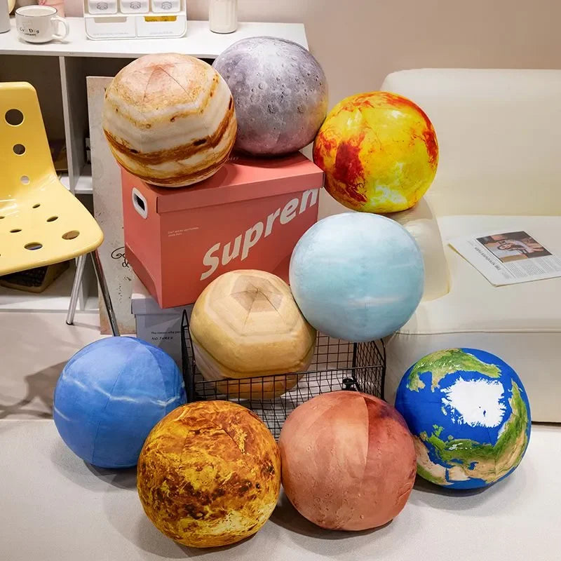 A collection of round, soft plush toys in various colors like yellow, orange, blue, and purple, displayed on a white surface.