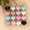 A set of five pink, white, and blue ghost silicone beads for jewelry making displayed on a woven mat.